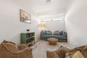 A compact living space with a sofa, a coffee table, a bookshelf, and a lamp.