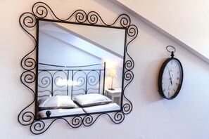 A bedroom with a bed, a nightstand, and a wall-mounted clock. - Ema Studio on the Main Promenade (Koper)