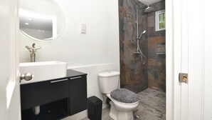 A modern bathroom with a shower, toilet, and sink. - Cozy studio apartment in beautiful Monchy with AC and king bed for your comfort. (Monchy)