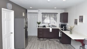 A modern kitchen with a refrigerator, stove, and sink. - Cozy studio apartment in beautiful Monchy with AC and king bed for your comfort. (Monchy)