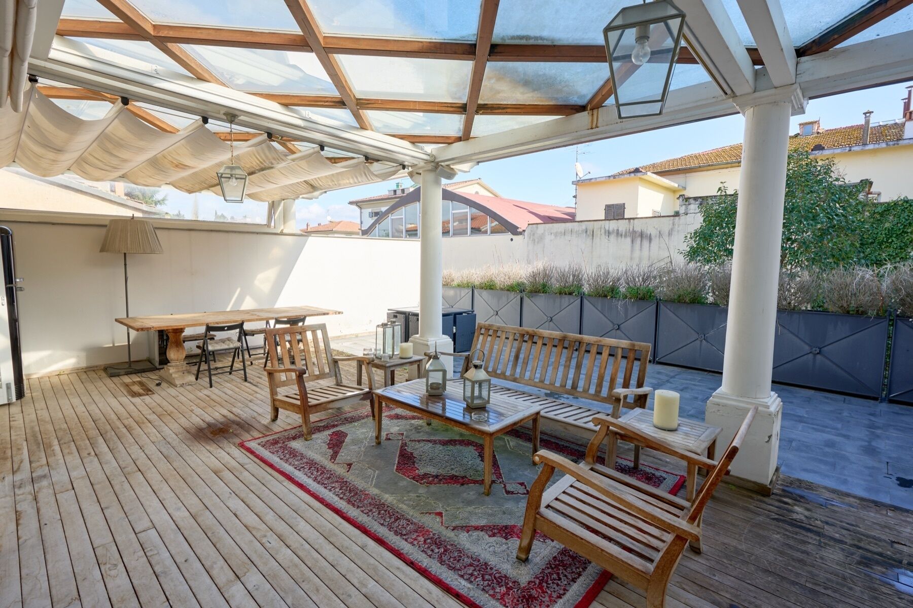 Eine Terrasse im Freien mit einem Holztisch, Stühlen und einer Bank.