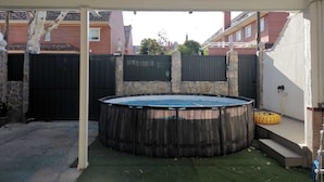 Una piscina al aire libre con un muro de piedra y una cerca de madera.