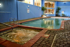 Ein Innenpool mit blauer Wand, einer Whirlwanne und einem gefliesten Boden.