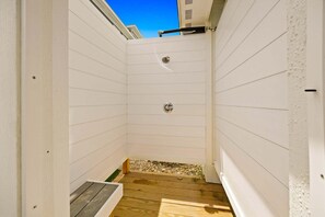 Un piccolo bagno separato con pavimento in legno e porta in metallo.
