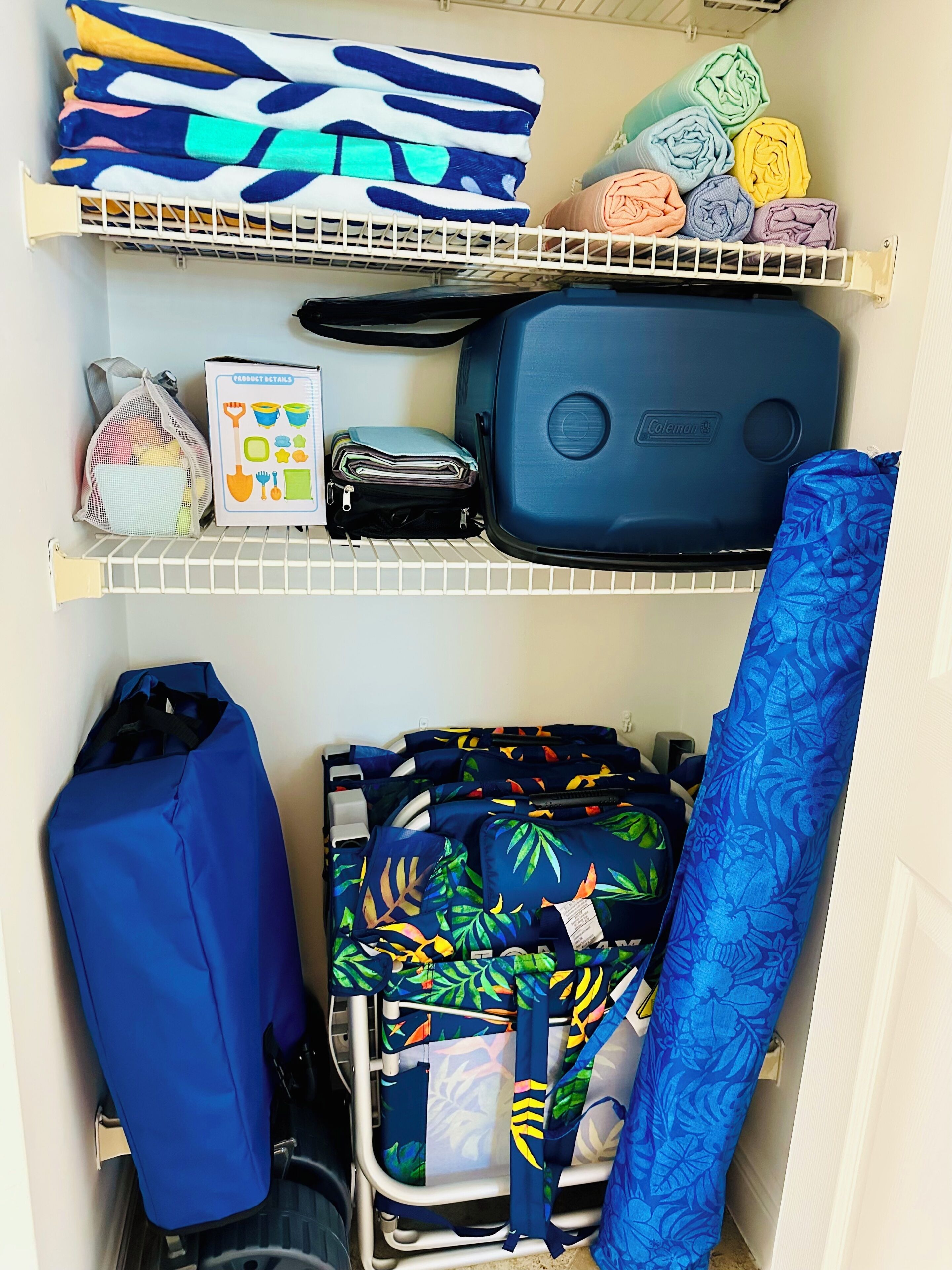 Un espace de rangement doté d’étagères où sont entreposées des couvertures pliées, une valise, un sac et un tableau présentant les caractéristiques du produit.