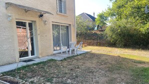 A house with a patio area, a small garden, and a view of a neighboring house. - 3-room NE apartment on the garden level (Varetz)