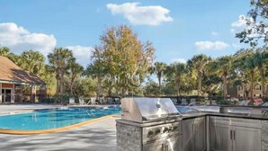 An outdoor pool area with a built-in grill and a stone structure. - Mins 2: VA, UF SanteFe U, UF Shands, HCA ,Airport (Gainesville)