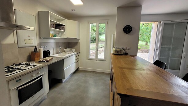 Una cocina moderna con estufa a gas, horno y encimera de madera.