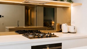 A modern kitchen with a gas stove, a coffee maker, and a toaster. - The Elysian on Margaret at Queen's Wharf (Brisbane City)