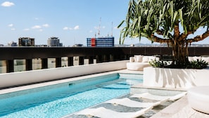 A rooftop pool with a clear view of the city skyline, including several high-rise buildings and construction cranes. - The Elysian on Margaret at Queen's Wharf (Brisbane City)