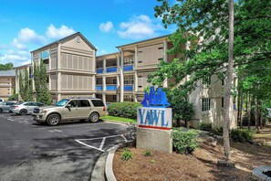 A multi-story building with a sign reading 'YAWL' and a parking lot with several cars. - Tall Ship 337 Keowee Key (Salem)