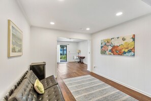 A spacious hallway with a sofa, a rug, and artwork on the walls. - Eagles Point Waterfront Oasis (Seneca)