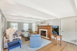 A living room with a fireplace, a television, and a sofa. - Eagles Point Waterfront Oasis (Seneca)