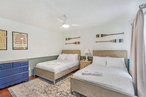 A hotel room with two beds, a ceiling fan, a nightstand with a lamp, and a blue dresser. - Eagles Point Waterfront Oasis (Seneca)
