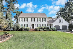 A two-story house with a front porch, a garage, and a well-maintained lawn. - Eagles Point Waterfront Oasis (Seneca)
