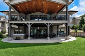 A two-story house with a covered patio area, outdoor seating, and a hot tub. - McAlister Rd Simply Spectacular (West Union)