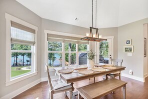 A dining room with a large wooden table, chairs, and a hanging light fixture. - McAlister Rd Simply Spectacular (West Union)