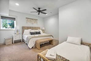 A bedroom with a bed, bedside tables, a ceiling fan, and a window with a view of greenery. - McAlister Rd Simply Spectacular (West Union)