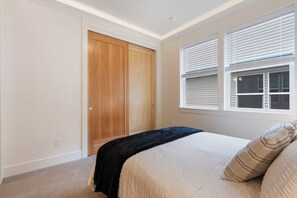 Makuuhuoneessa on sänky, vaatekaappi ja ikkuna, jossa on sälekaihtimet.