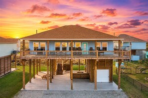 A two-story house with a balcony, a covered front porch, and a garage. - Modern Interior l 2 Arcade Games l Inflatable Tub (Crystal Beach)