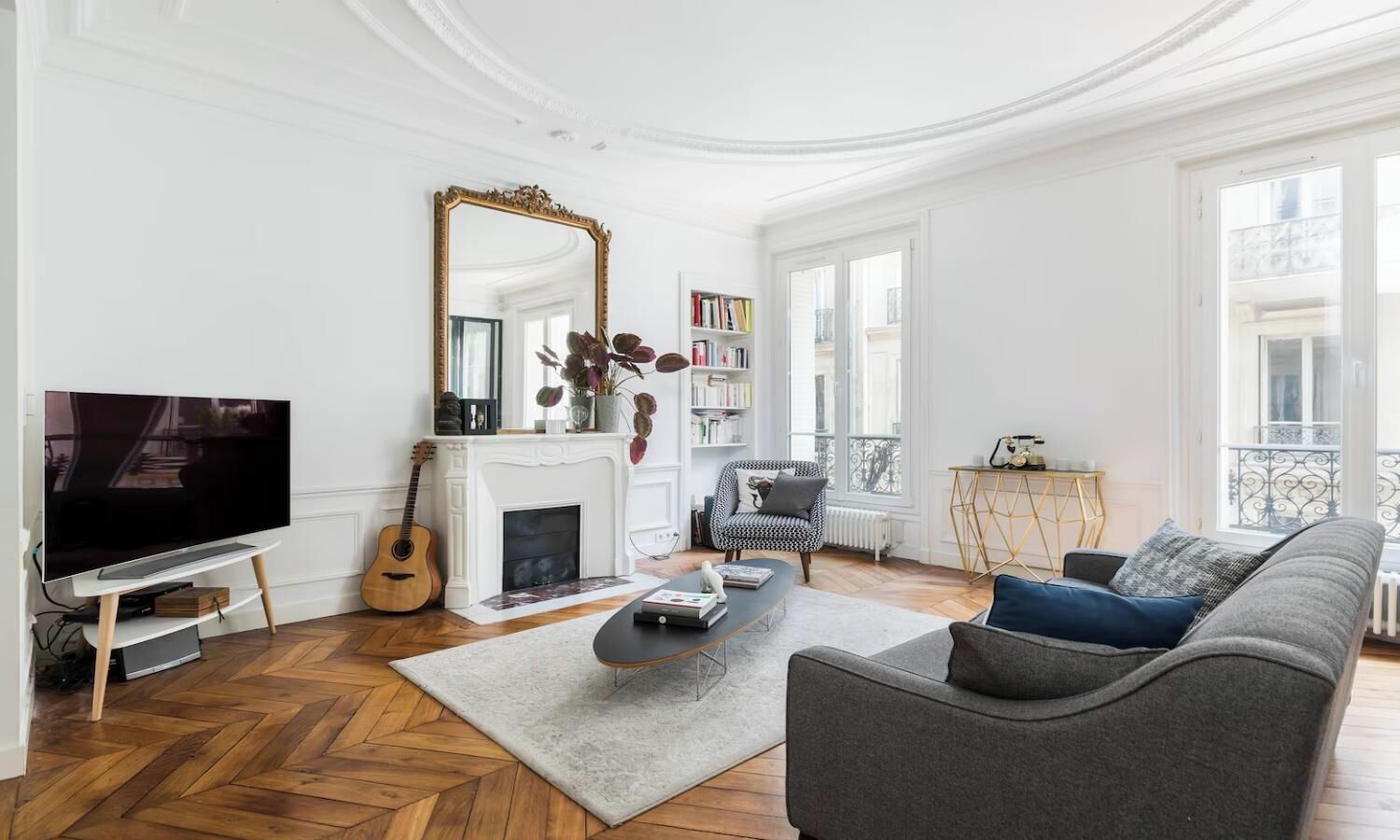 A living room with a fireplace, a television, a sofa, and a bookshelf.
