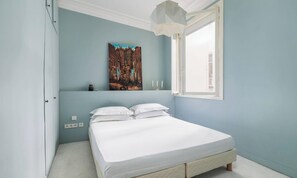 A bedroom with a bed, a window, and a painting on the wall. - A CLASSIC FRENCH ARCHITECTURE  WITH STYLISH CONTEMPORARY DESIGN-SAINT GERMAIN (Paris)