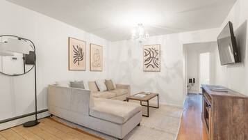 A modern living room with a sofa, a coffee table, and artwork on the walls.