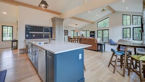 Una cocina amplia con una isla grande, electrodomésticos modernos y una zona de comedor con barra.