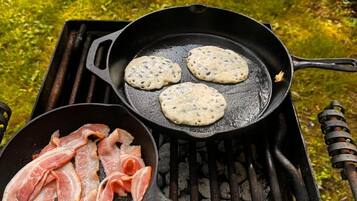 Un plat composé d’une portion de trois crêpes et d’une poêle de lardons.
