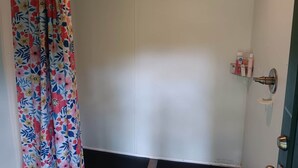 A bathroom with a shower curtain, a toilet, and a sink with toiletries.
