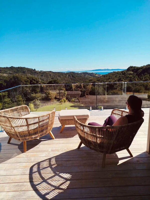 A balcony with wicker furniture and a view of the sea.