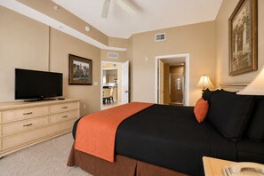 A hotel room with a bed, a television, a desk, and a door leading to a bathroom. - Disney Doorstep Resort Vibes Stay. (Orlando)