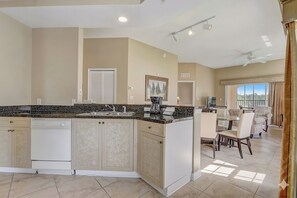 A modern kitchen with a central island, built-in appliances, and a dining area with a view. - Disney Doorstep Resort Vibes Stay. (Orlando)