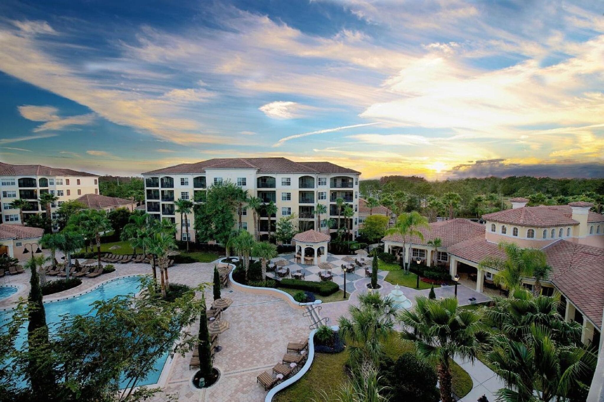 Un resort con varias construcciones, piscina y zonas ajardinadas.