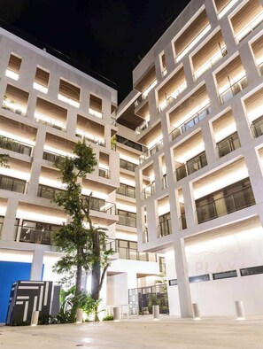Ein mehrstöckiges Gebäude mit modernem Design, das Balkone und große Fenster aufweist.