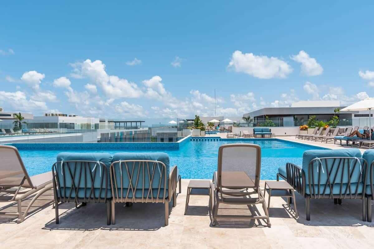 Ein Poolbereich auf dem Dach mit Liegestühlen und freiem Blick zum Himmel.