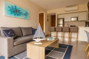 Ein modernes Wohnzimmer mit einer Couch, einem Couchtisch und einem Modell eines Segelboots.