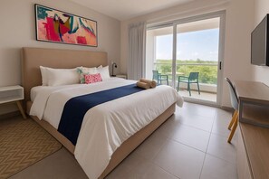 Ein Hotelzimmer mit einem großen Bett, einem Schreibtisch, einem Fernseher und einem Balkon mit Blick.