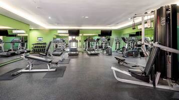 A gym with treadmills, elliptical machines, and weight machines.