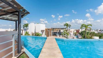 A swimming pool with a clear view of the surrounding buildings and palm trees.
