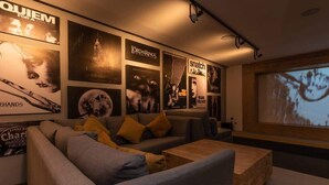 En moderne stue med en grå sofa, et træ sofabord og et stort tv til film.