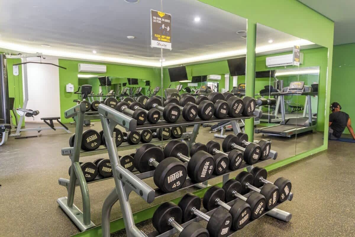 Une salle de sport équipée de matériel de musculation, de tapis de course et d’appareils d’exercice.