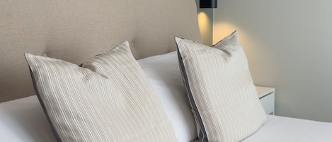 Ein Bett mit zwei Kissen und einem Kopfteil mit einer Lampe.