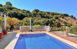 A swimming pool with a white balustrade, surrounded by potted plants and a view of a hillside. - Amazing home in Frigiliana (Frigiliana)
