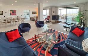 A modern living room with a sofa set, a dining area, and a TV. - Amazing apartment in Estepona with swimming pool (Estepona)