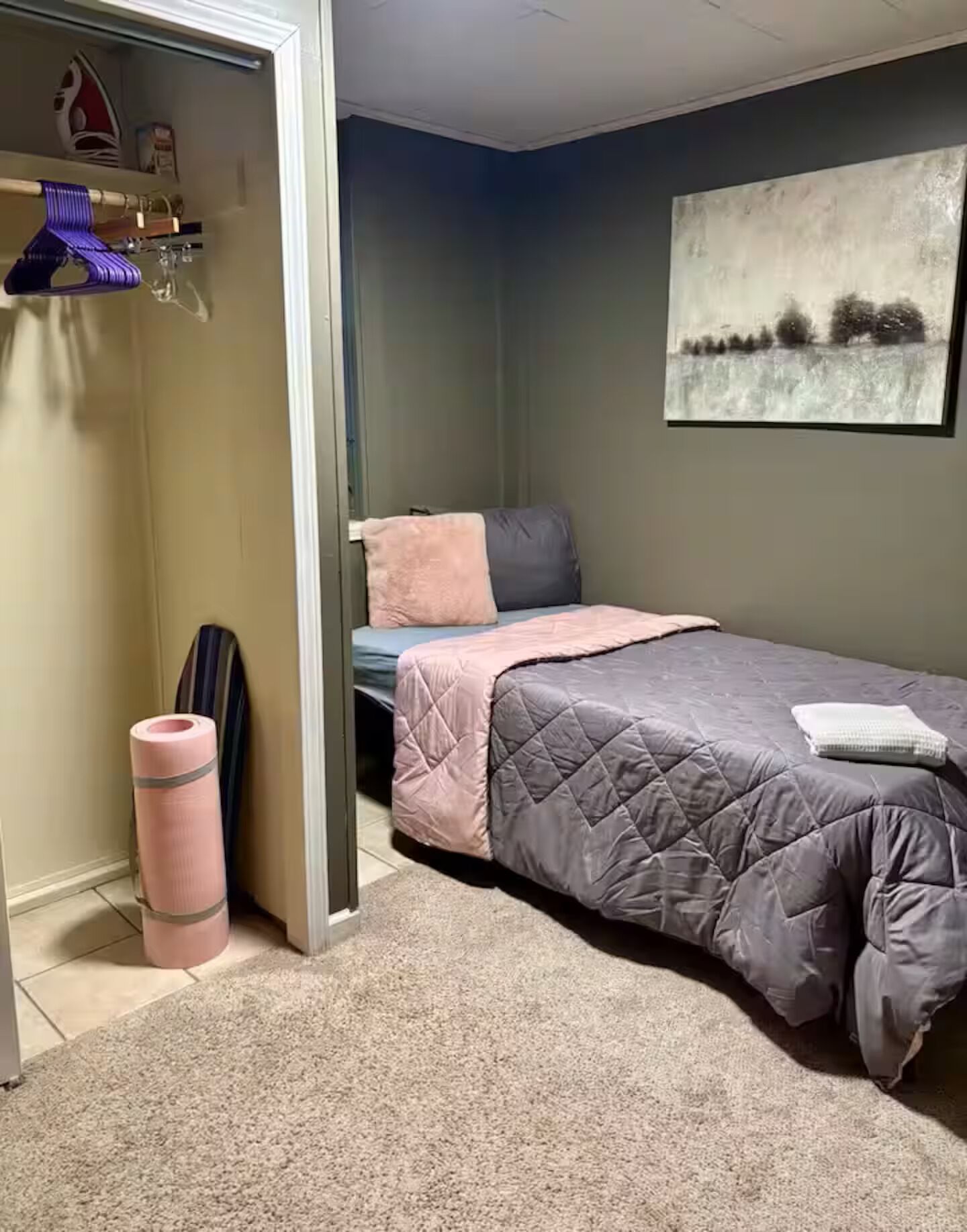 Un dormitorio con cama, armario y un cuadro en la pared.