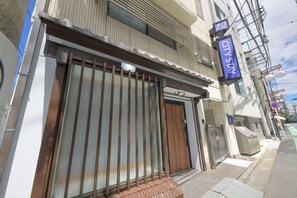 A hotel entrance with a metal gate, a wooden door, and a blue sign indicating 'City Stay'. - Shinjuku 6-chome City Stay 1F (Shinjuku)