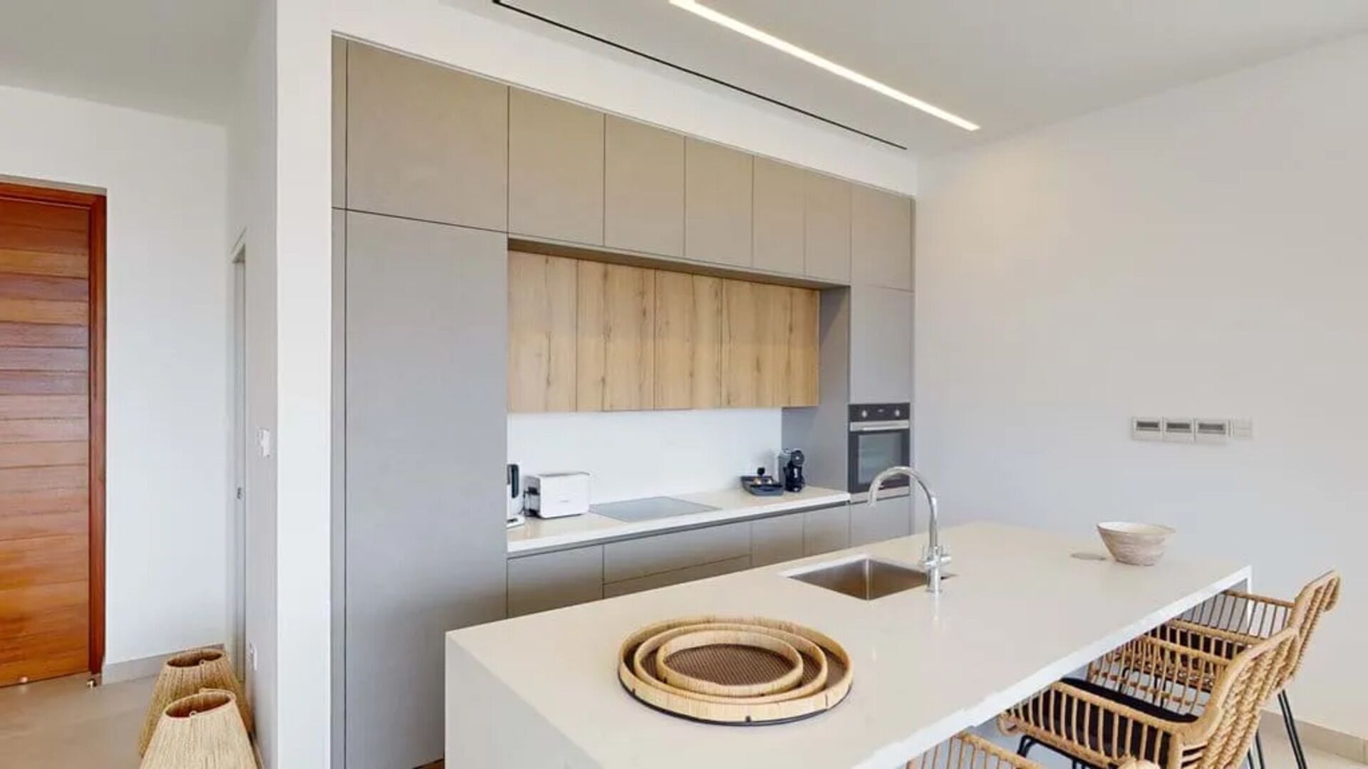 Una cocina moderna con una isla central, electrodomésticos integrados y un diseño minimalista.