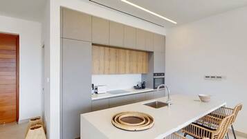 Una cocina moderna con una isla central, electrodomésticos integrados y un diseño minimalista.