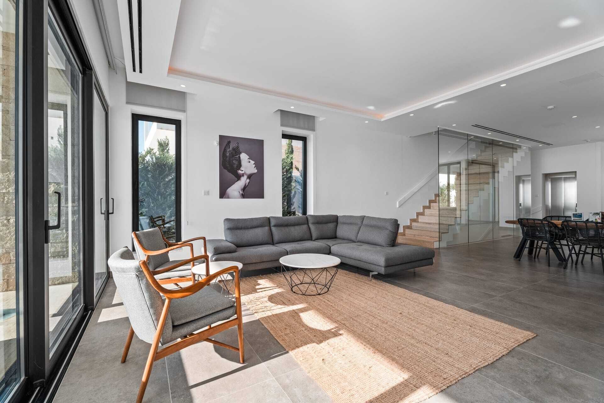 A modern living room with a sectional sofa, a round coffee table, and a dining area with chairs.
